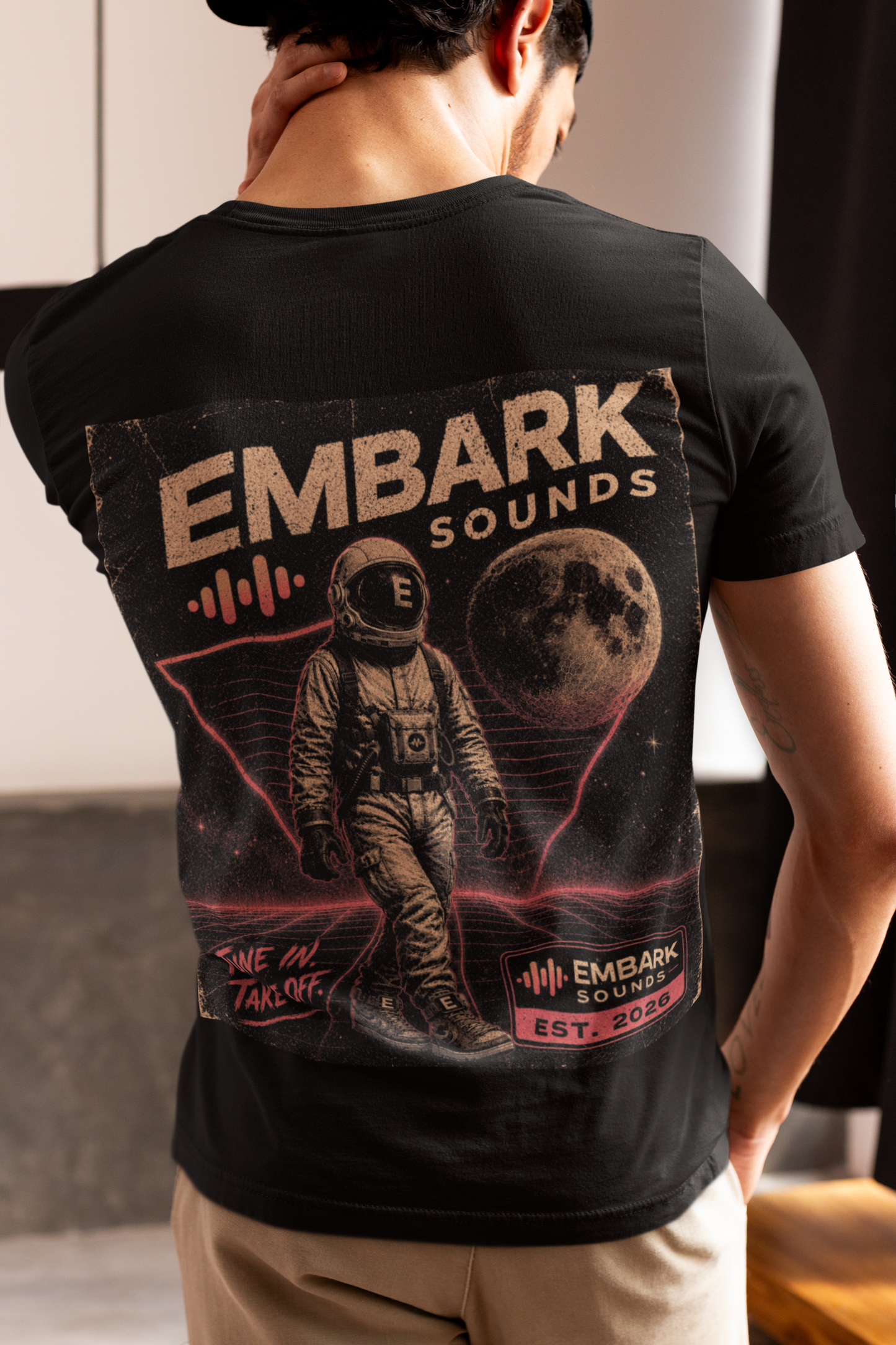 Person wearing a black t-shirt with 'Em bark Sounds' design on the back
